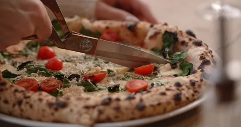 Client of the pizzeria cuts the Neapolitan pizza by the scissors Stock Footage 282965850