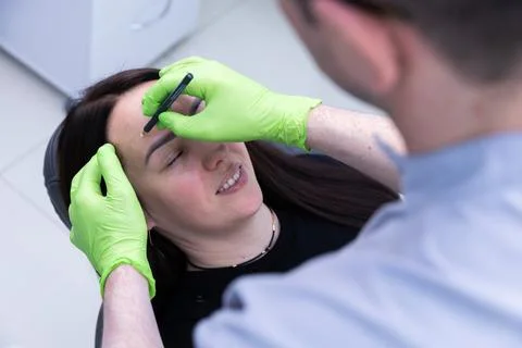 A Client Receiving Professional Eyebrow Shaping Through Precision Techniques Stock Photos