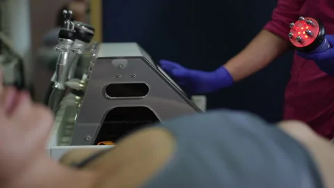 Client reclining during treatment using portable LED wand in spa setting  Stock Footage 326065204
