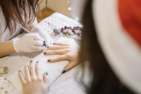 Client with Santa hat doing manicure at nail salon Foto stock