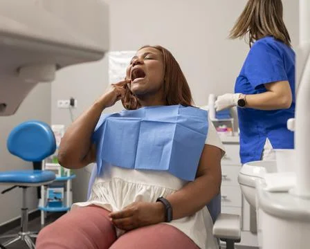 A client shows where she has the pain at the dental clinic Stock Photos