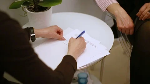 Client signing the agreement and shaking hands with her cosmetician Stock Footage 76031266