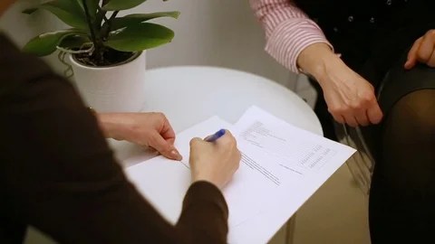 Client signing the contract and shaking hands with her cosmetician Stock Footage 76031298