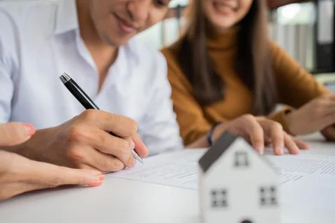 Client signs home loan document to buy homes with real estate property agent  Stock Photos