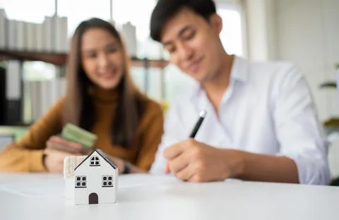 Client signs home loan document to buy homes with real estate property agent  Stock Photos