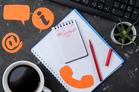 Client support service. Contact us for feedback. Desktop with notepad and gla Stock Photos