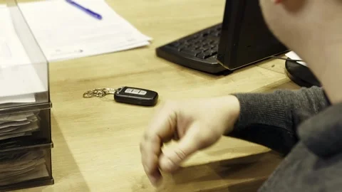 Client taking car key from dealer in salon at the table. Car dealer giving key Stock Footage 281582366