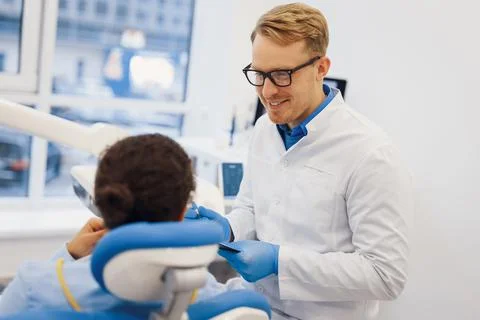Client talking with handsome dentist Stock Photos