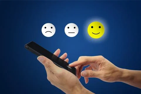 The client using hand choose happy face smile icon on smartphone. Stock Photos