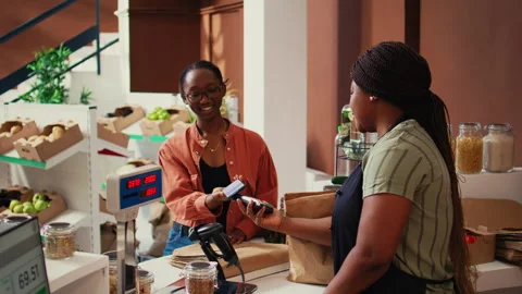 Client using nfc payment at pos to buy eco products Stock Footage 262383583