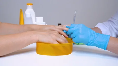 Clients hand and the nail master in processing nails in gloves  raise a cuticle Stock Footage 116984781