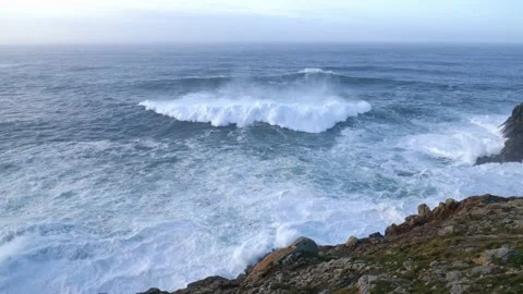A cliff on the Atlantic. A big wave breaks with spray. Stock Footage 135149652