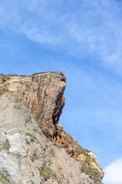 Cliff  on a beach, blue sky Stock Photos