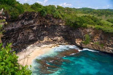 Cliff broken by wave of ocean formed perfect paradise untouched beach. Natura Stock Photos
