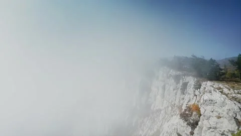 A cliff on the cliff, over which the fog cannot rise. Free space for a logo or Stock Footage 218403526
