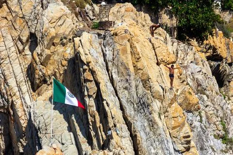 Cliff diver standing with open arms, preparing to jump. Stock Photos
