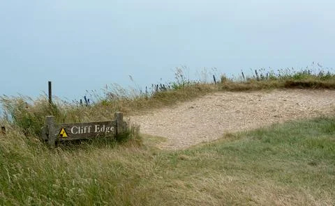 Cliff edge warning sign. Caution crumbling slope. Risk of injury or death Stock-Fotos
