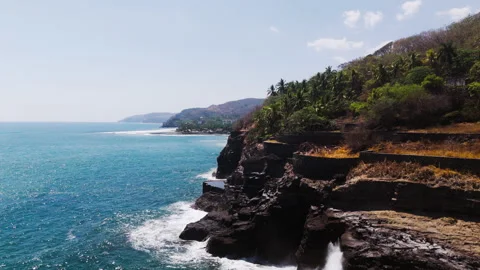 Cliff face above beautiful ocean waves Stock Footage 333204457