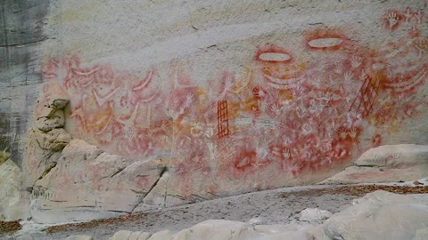 Cliff face with indigenous engravings, Ochre stencils, many 1000's of years old Stock Footage 140609153