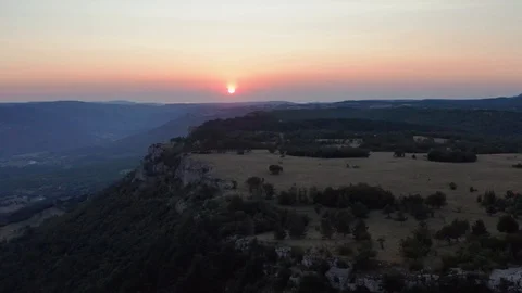 Cliff with forests and meadows with a red sunset backdrop Stock Footage 124252402