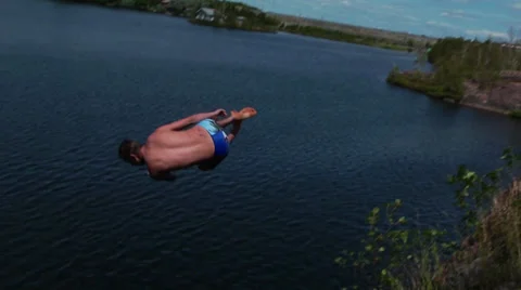 Cliff jumper does a side flip into water (lincoln loop) Stock Footage 27693177