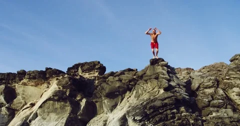 Cliff jumping into blue ocean at sunset Stock Footage 71366320