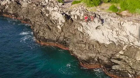 Cliff Jumping into Ocean. Aerial View Slow Motion. Young Man Jumps off Cliff  Vídeo Stock 57223053
