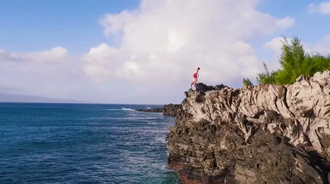 Cliff Jumping into Ocean. Aerial View Slow Motion. Young Man Jumps off Cliff  Video stock 57223247
