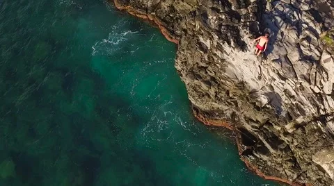 Cliff Jumping into Ocean. Aerial View Slow Motion. Young Man Jumps off Cliff  스톡 동영상 57223284