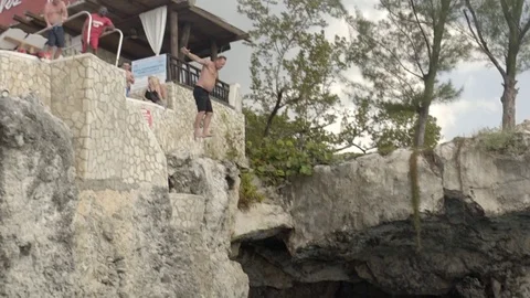 Cliff jumping at Ricks Cafe in Negril, Jamaica. Filmed in Super Slow Motion. Stock Footage 73138225