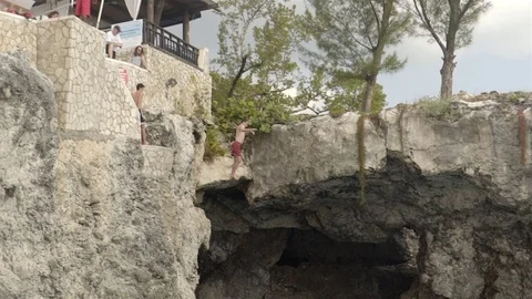 Cliff jumping at Ricks Cafe in Negril, Jamaica. Filmed in Super Slow Motion. Stock Footage 73138440