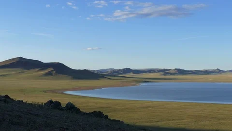 Cliff with low vegetation against the backdrop of the lake and mountains. Video stock 89676148