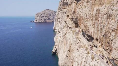 Cliff over Mediterranean sea with access to the Neptune's cave in Sardina Stock Footage 308044143