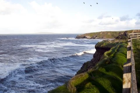 Cliff path and storm waves Stock Photos