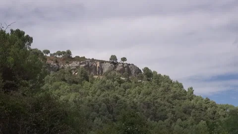 Cliff pine trees mountain peak clouds sky countryside nature sunlight beautif Stock Footage 330468497