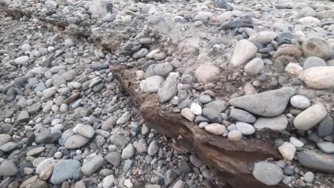 Cliff river rocks, a collection of pebbles, hard material texture in the form Stock Footage 251845132