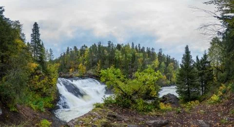 Cliff, stone wall, forest, waterfall and wild river panoramic view in autumn. Stock Photos