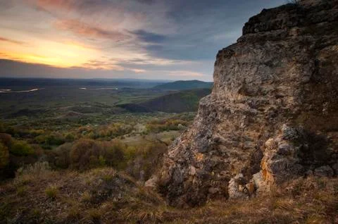 Cliff at sunset with clouds on the sky Stock Photos