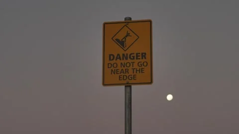 Cliff top warning sign with full moon slow motion 4K Stock Footage 273431100