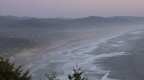 Cliff view of an ocean moving towards a small town Stock Footage 8683587