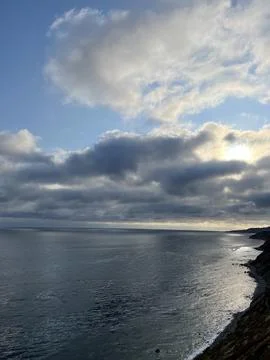 Cliff View Overlooking the Pacific Ocean and Storm Clouds During Sunset Stock Photos