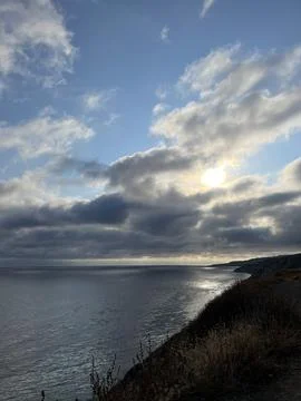 Cliff View Overlooking the Pacific Ocean and Storm Clouds During Sunset Photos