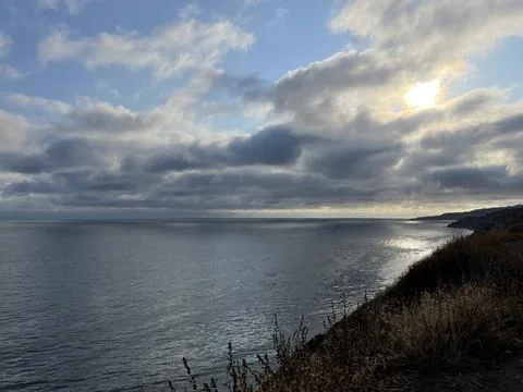 Cliff View Overlooking the Pacific Ocean and Storm Clouds During Sunset Stock Photos