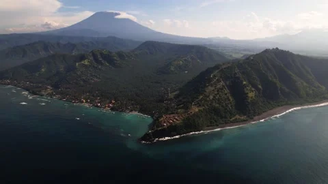 A cliff with a volcano behind it - Agung in Bali Stock Footage 197931489