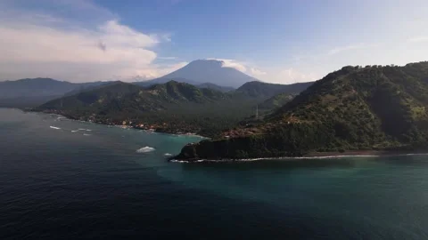 A cliff with a volcano behind it - Agung in Bali Stock Footage 197931553