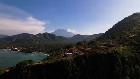 A cliff with a volcano behind it - Agung in Bali Stock Footage 197932565