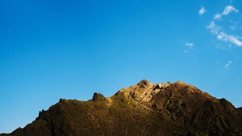 Cliffs against the sky, an old brown mountain peak, bare and rocky, Фото