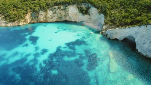 Cliffs and hidden beach cove with clear blue waters in summer Kefalonia Greece Stock Footage 341349449