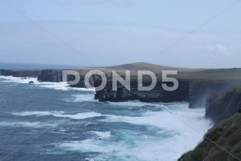 Cliffs and lapping waves, ireland. Stock Photos