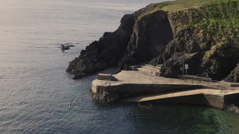 Cliffs off the coast of cooper in Ireland. People bathing in the ocean Vídeos de archivo 153411529